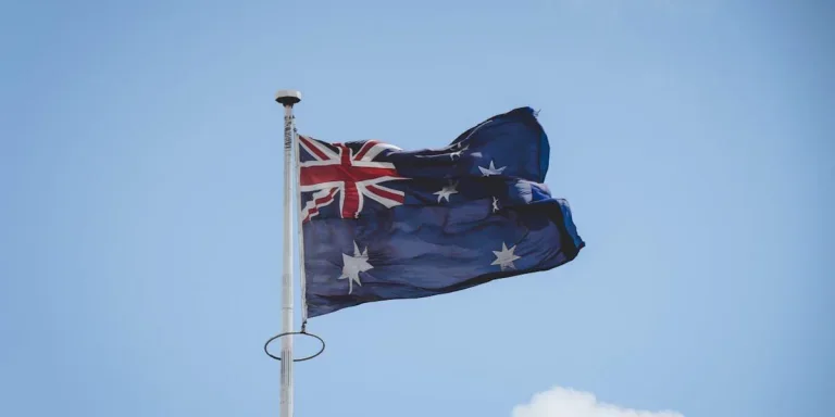 The Australian flag fluttering gracefully against a clear blue sky