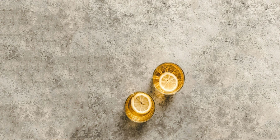 Two Glasses of Lemonade With Lemon Slices on Top, Placed on a Marble Surface