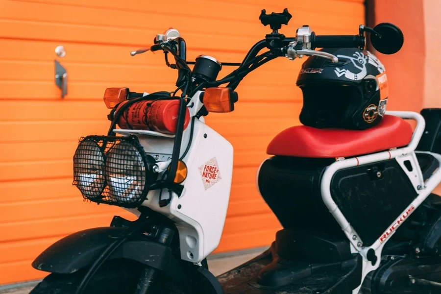 White and Black Scooter in Front of an Orange Wall