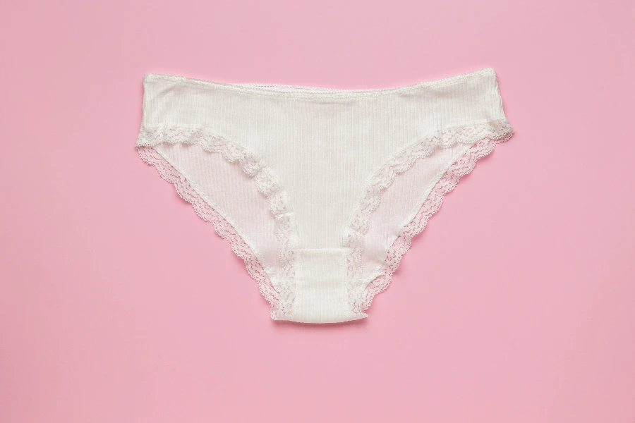 White women's cotton lace panties on a pink background