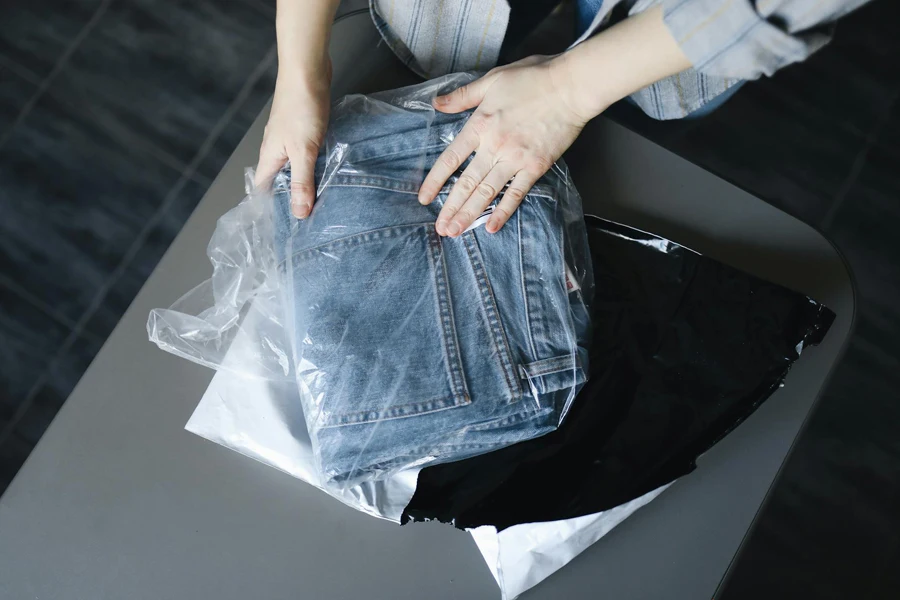 Woman Packing Jeans into Plastic Bag