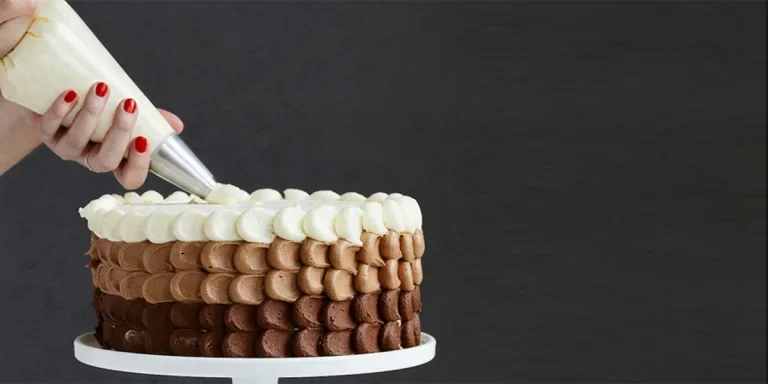 Woman icing layered cake with frosting bag