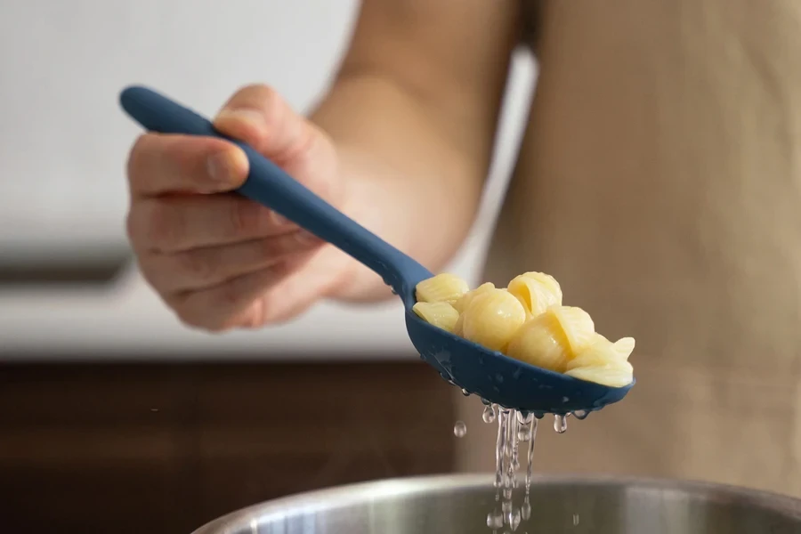 Woman removing food with a slotted spoon