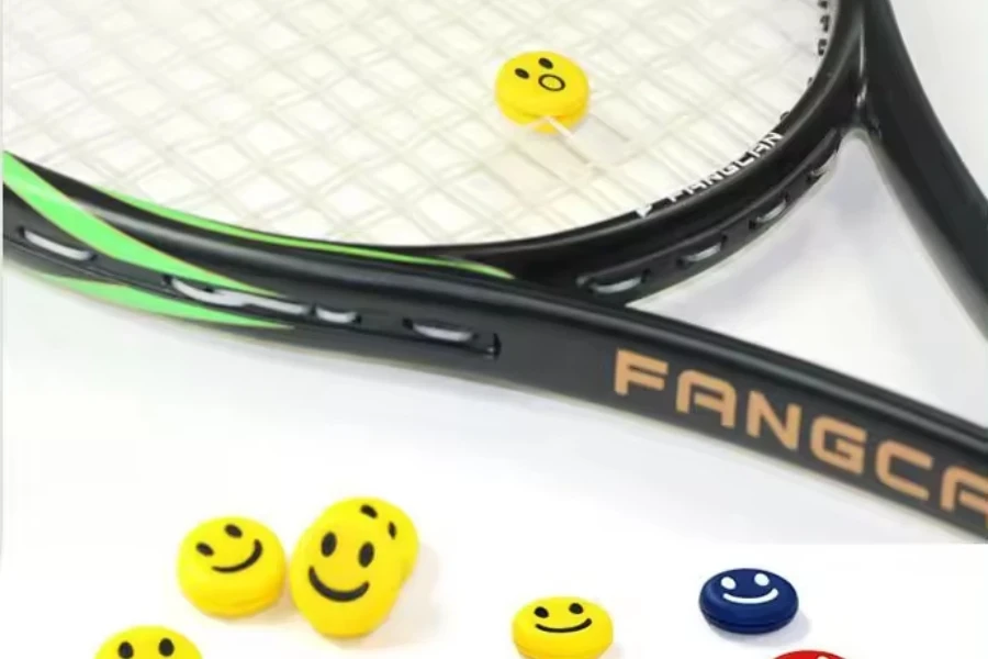 Yellow smiley tennis dampener on stringed tennis racquet