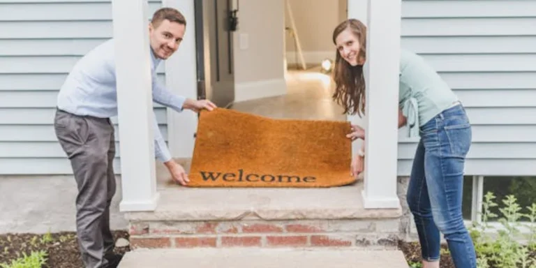 A man and woman holding a doormat