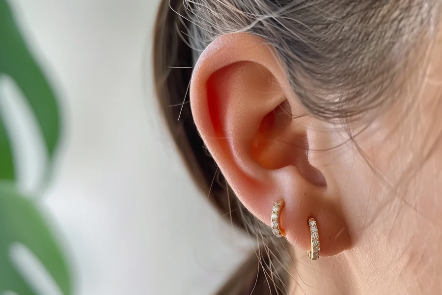a pair of two-tone huggie earrings.
