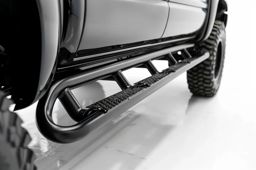 a photo of the side bars and steps on an all black truck