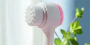 Un cepillo limpiador facial blanco con cabezal revestido de silicona.