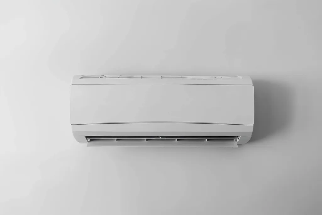 A white air conditioner with the fan on is shown against a pure white background