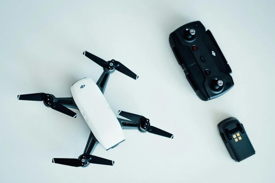 Drone on a white background beside controller and battery