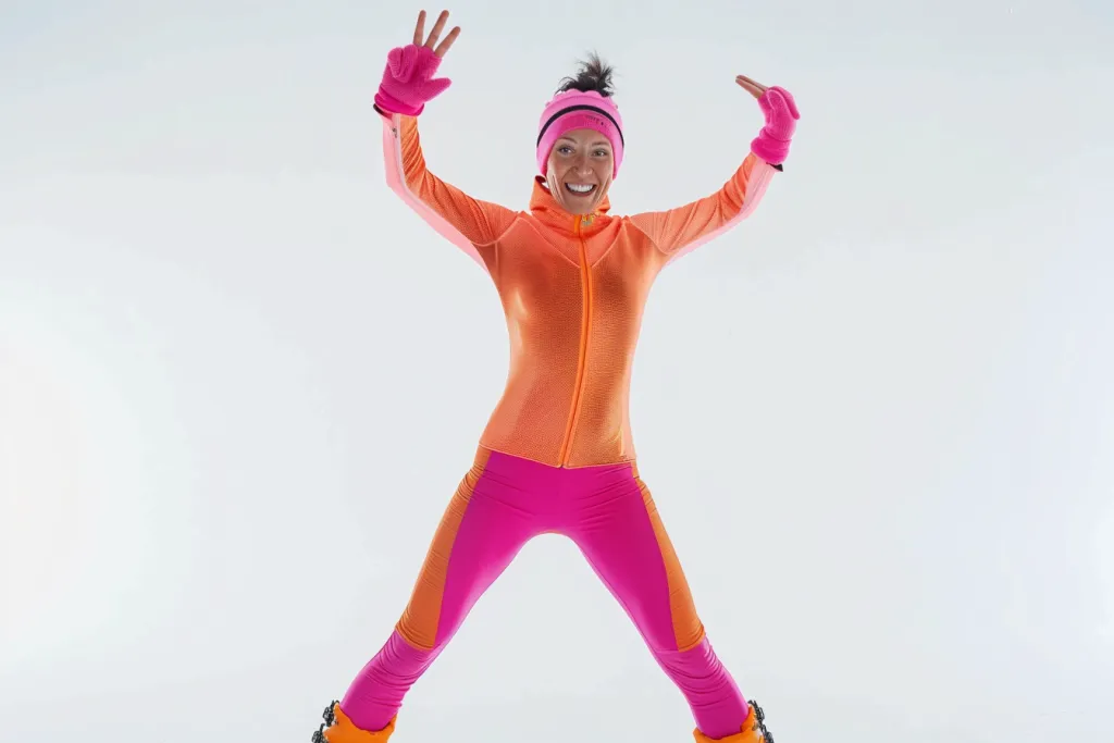 full body shot of a smiling happy woman in a pink and orange colored skidress