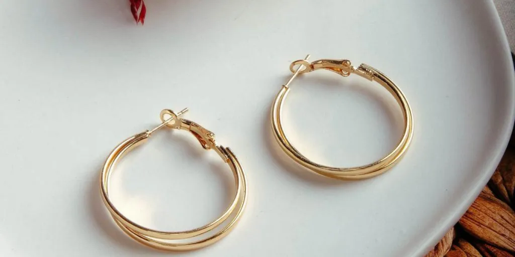 gold pair of huggie earrings on white plate