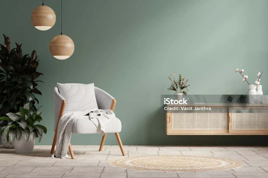 Green wall with gray armchair and decor in living room