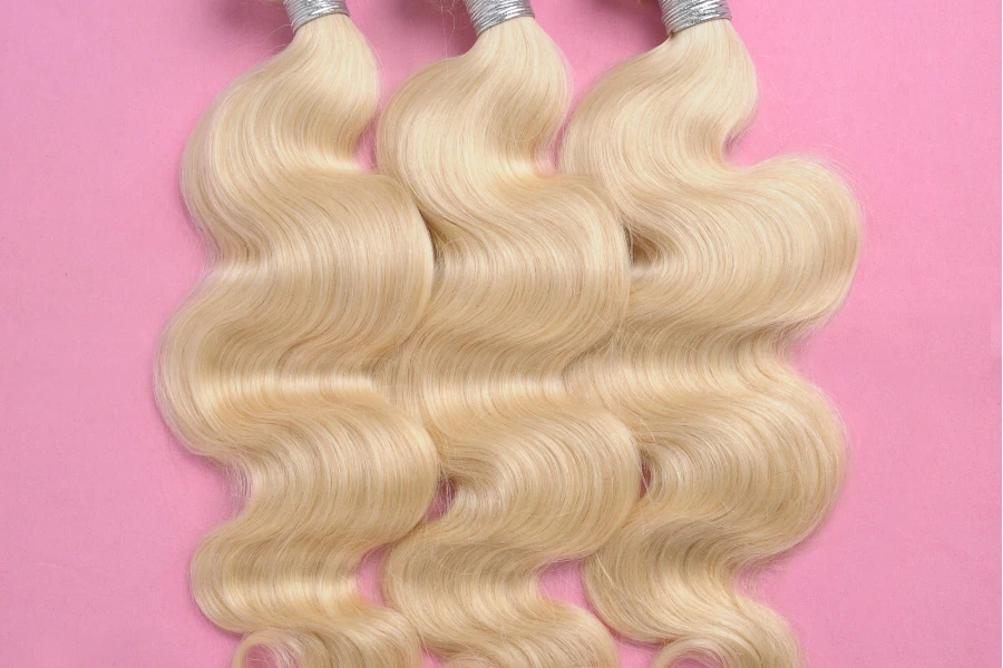 blonde wavy hair on pink background

