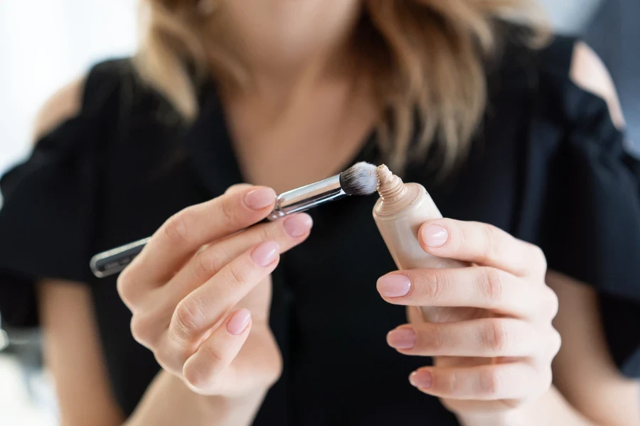 Hands makeup artist. In the hands of the makeup artist brush
