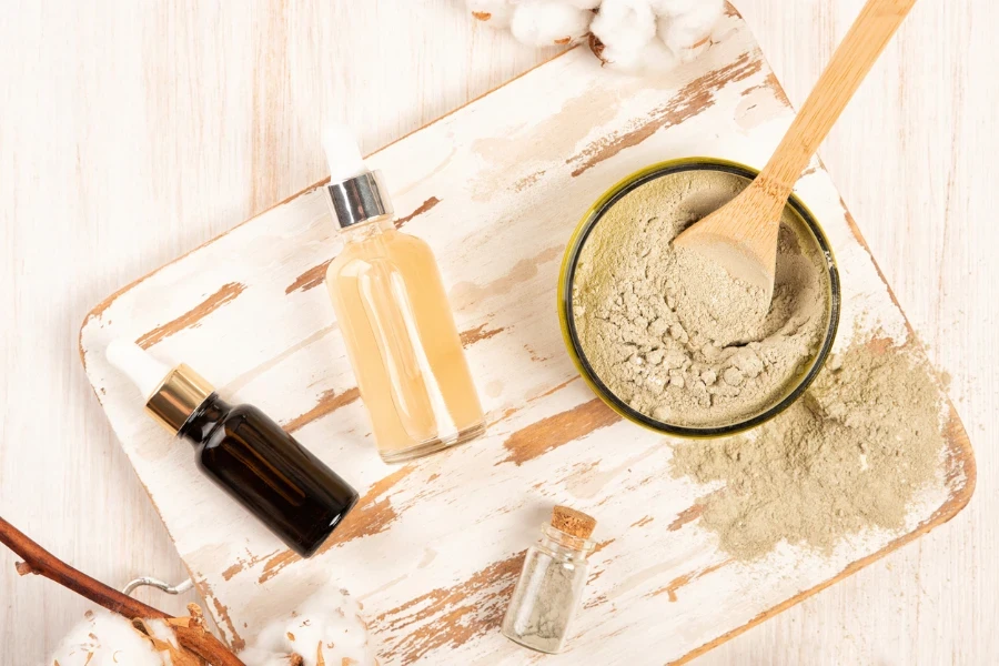 Dry facial clay powder mask in a jar and beauty essence bottles
