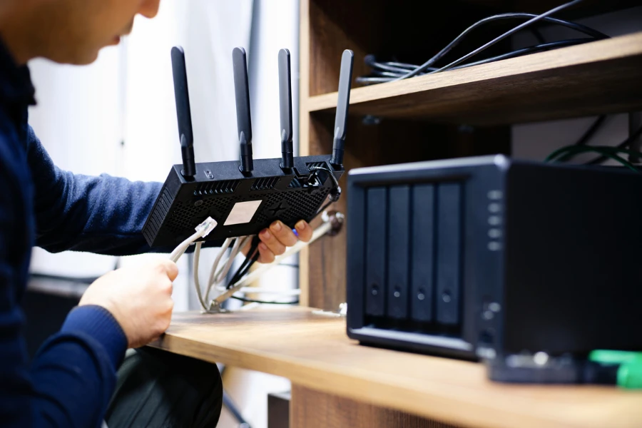Man Preparing Cables For For Network Attached Storage System