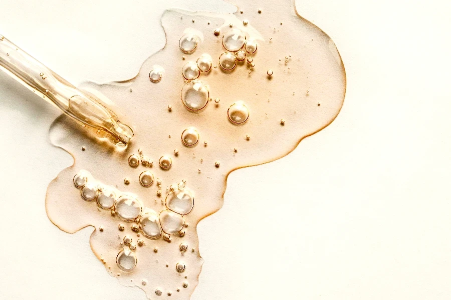 Yellow texture of a drop of whey or olive oil on a white background
