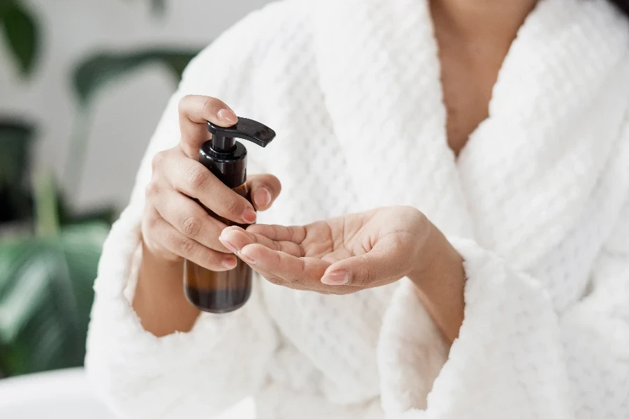 a woman is holding a bottle of oil cleanser