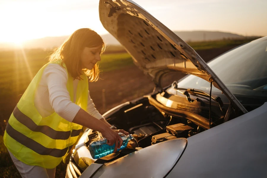 Closeup shot of hands holding bottle with antifreeze washer fluid