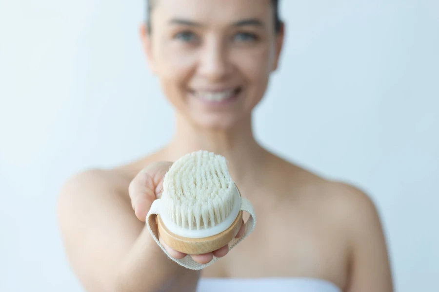 Midsection of caucasian female is showing dry brush with a toothy smile to camera
