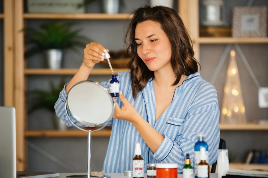 Young woman applying a serum to her face in her evening routine
