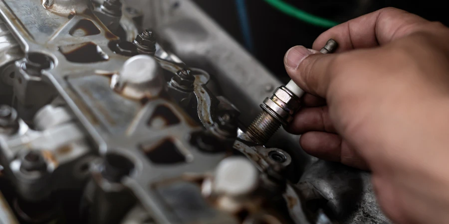 Old Car spark plug in a hand of Technician remove