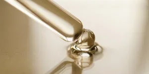 Pipettes with oil or serum on a golden background