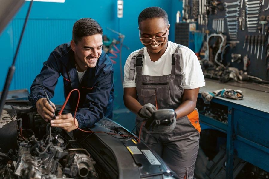 A young Caucasian male mechanic and his young African American female colleague