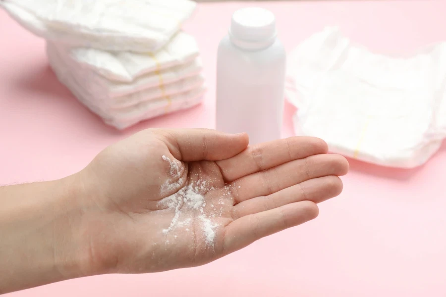 Woman with qasil powder on pink background
