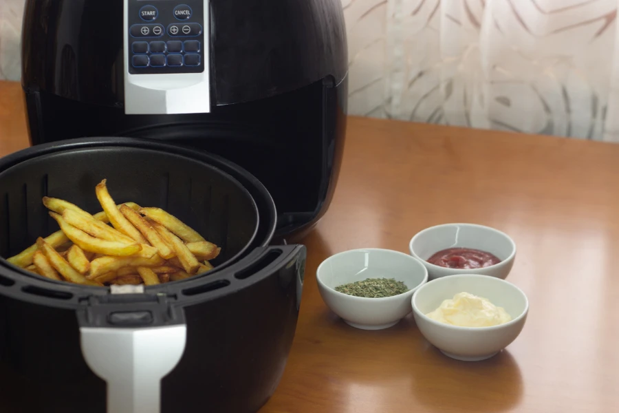 Air fryer with French fries on a table
