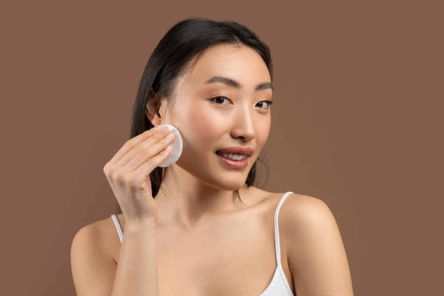 Sensual asian lady holding cotton pad for face
