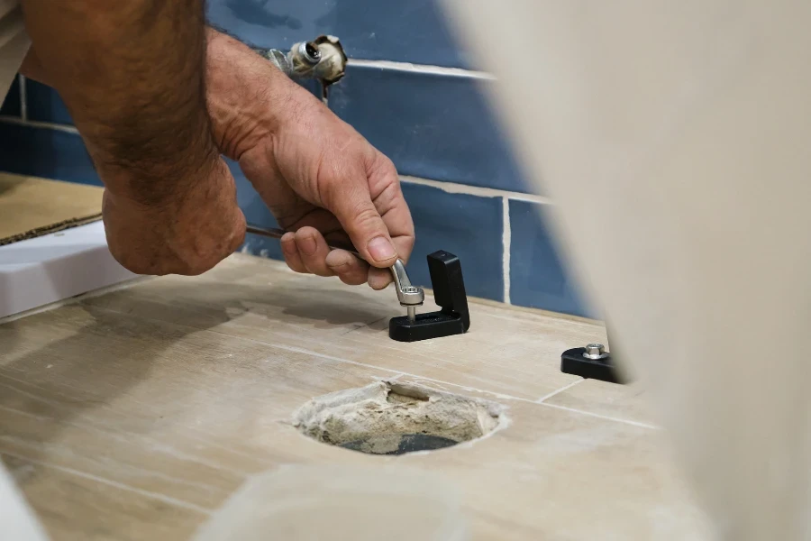 installer installing toilet drain flange in a house