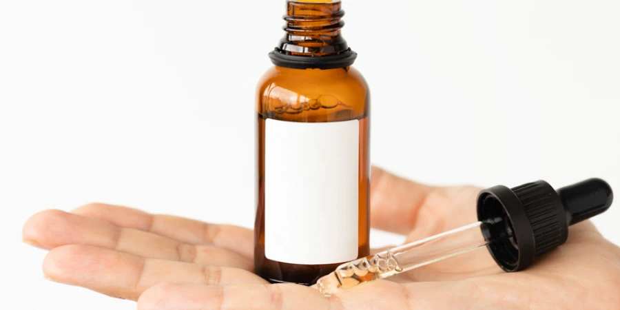 Hand is showing beauty serum bottle with white mockup space in front of white background