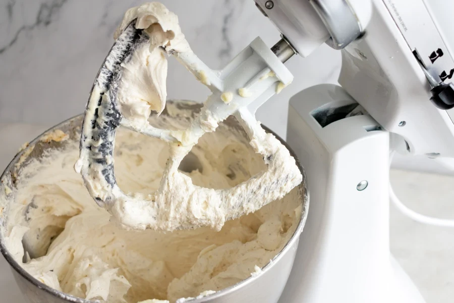 Mixed frosting in a stand mixer fitted with a paddle attachment
