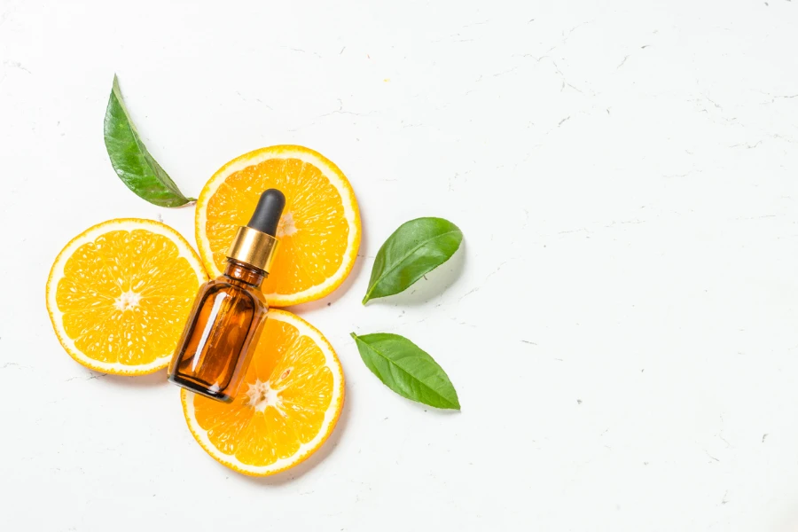 Fresh citrus fruits with serum bottles with vitamin cosmetic products
