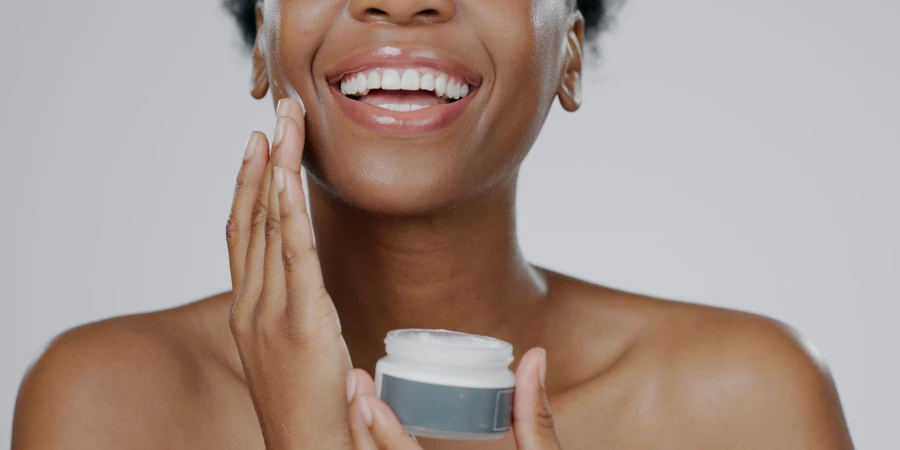 Black woman holding a jar of hydroquinone cream