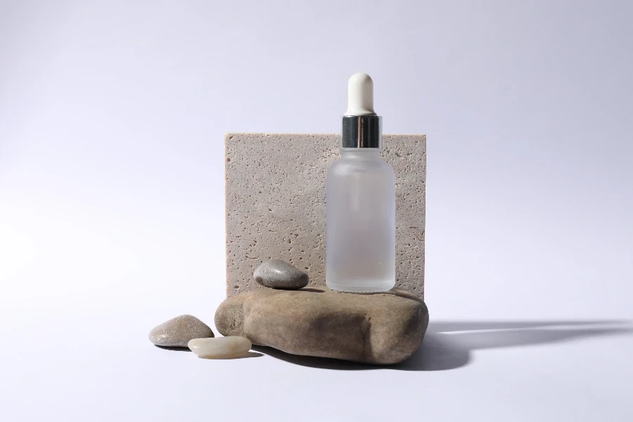 Composition with bottle of cosmetic serum on white background
