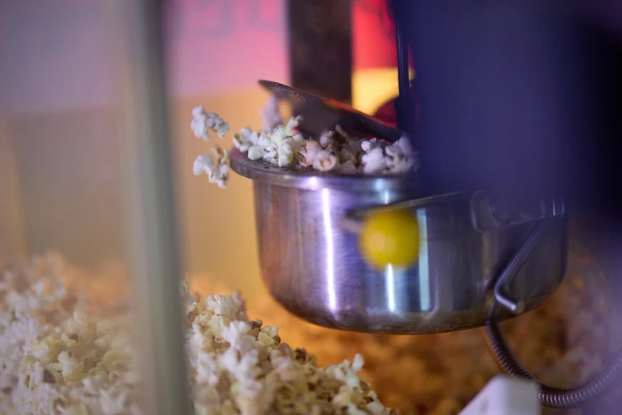 a vendor holding freshly popped popcorn to sell
