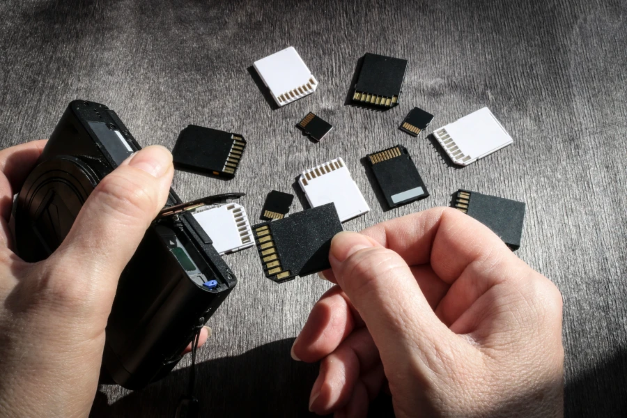 Close-up of hands inserting a memory card into the camera's memory slot