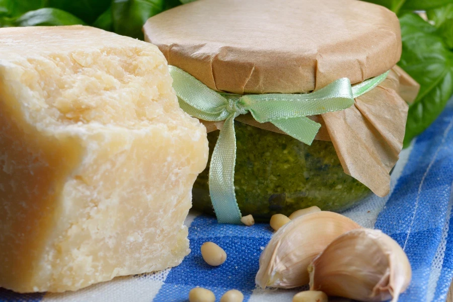 Homemade pesto sauce and ingredients on kitchen table
