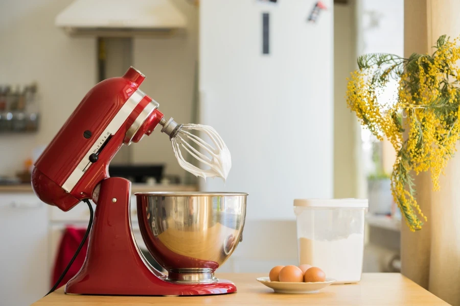 red stand mixer mixing white cream
