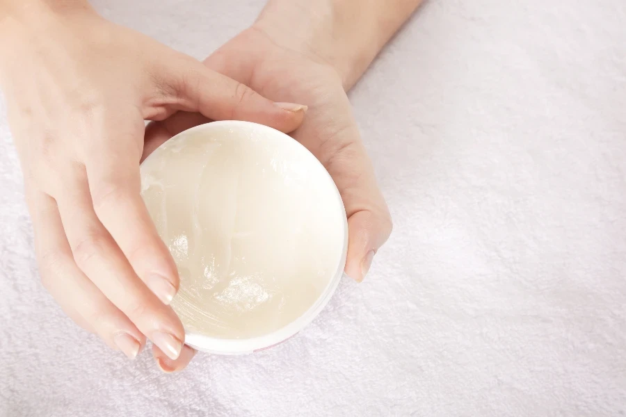 Closeup of female hands applying cream
