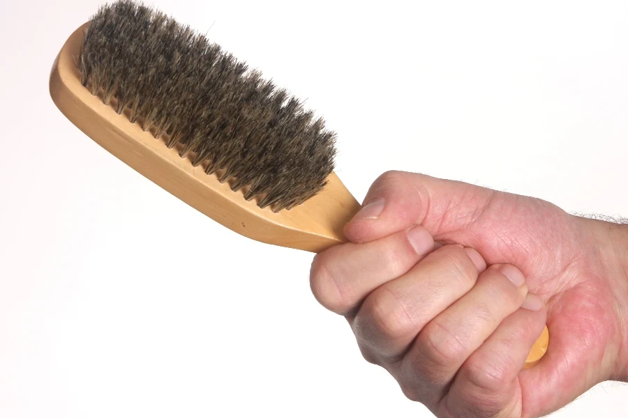 Hand holding hair brush
