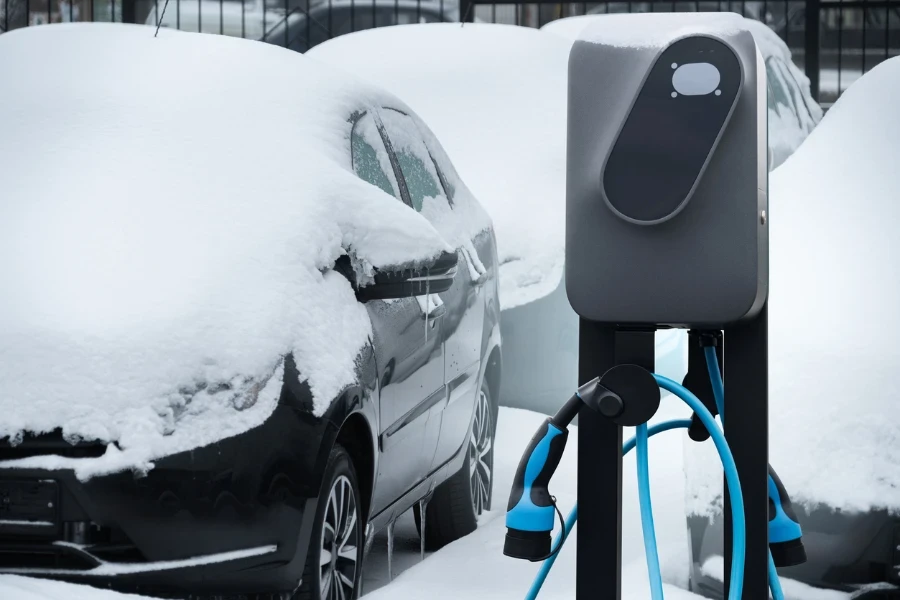 car charging station on a background of snow covered winter cars