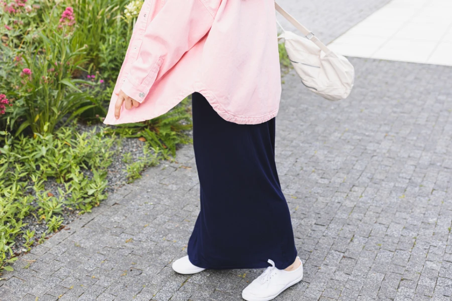 In pink oversized denim shirt outdoor and blue maxi skirt