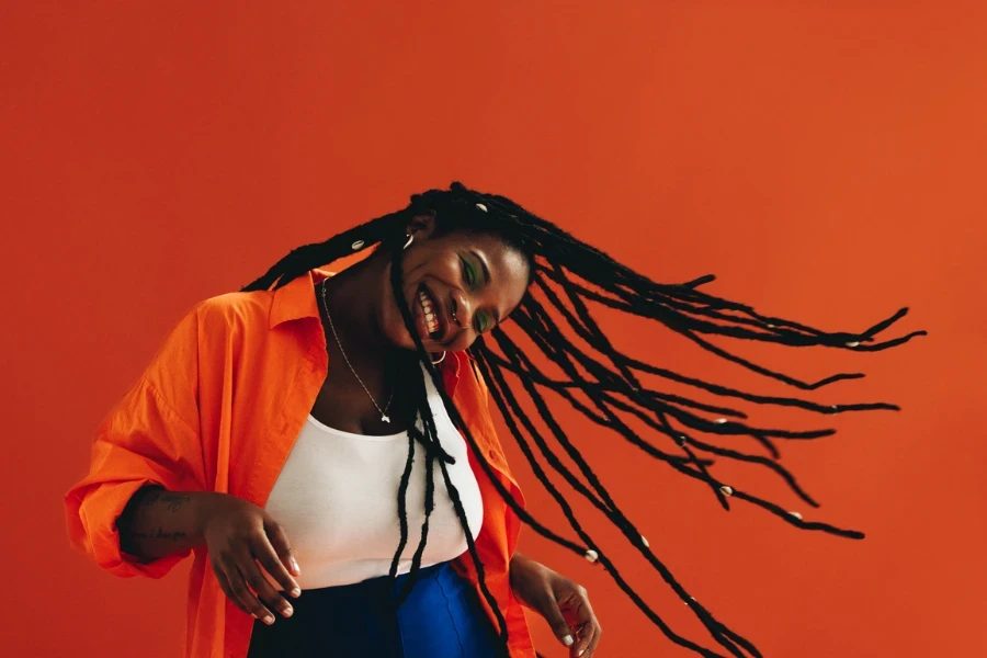 Happy young woman having fun with her dreadlocks