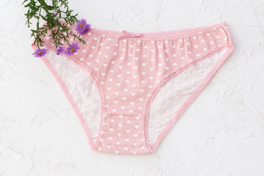 Pink cotton panties with flowers on the white structured background