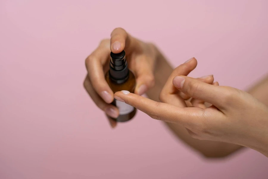 Person Holding Brown Serum Bottle