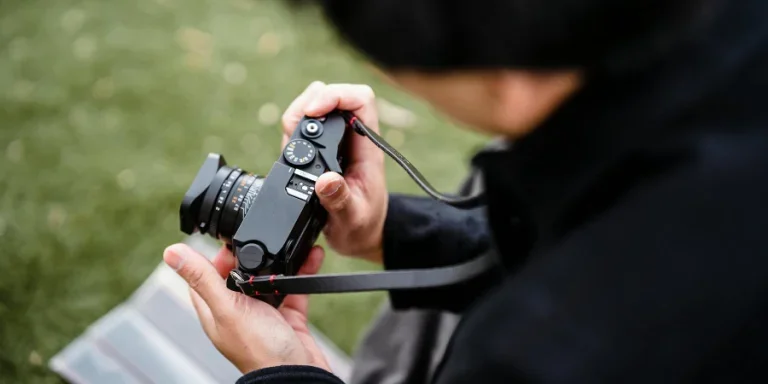 A Person in Black Long Sleeves Holding a Black Camera